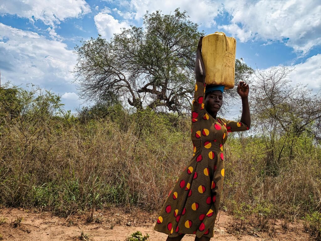 Woman carrying a container on her head in rural Kitgum, Uganda.